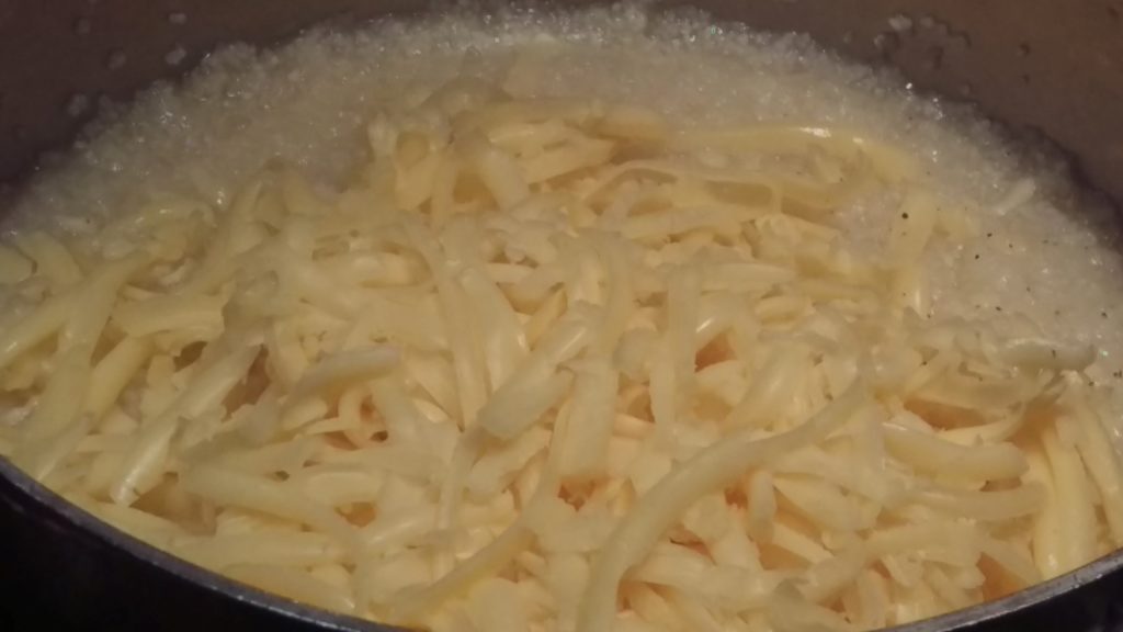 Melting the gouda into the grits